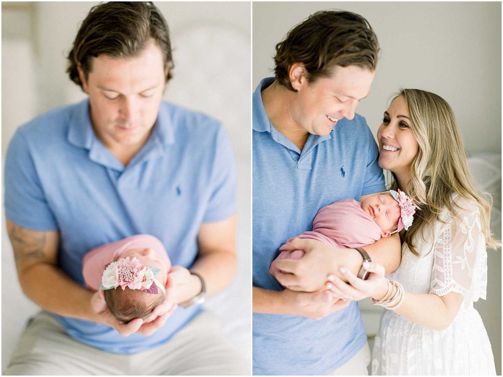 mom and dad hold baby girl